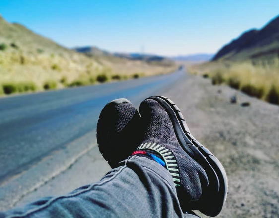 Girl on a road trip experience stops to take in the mountain view.