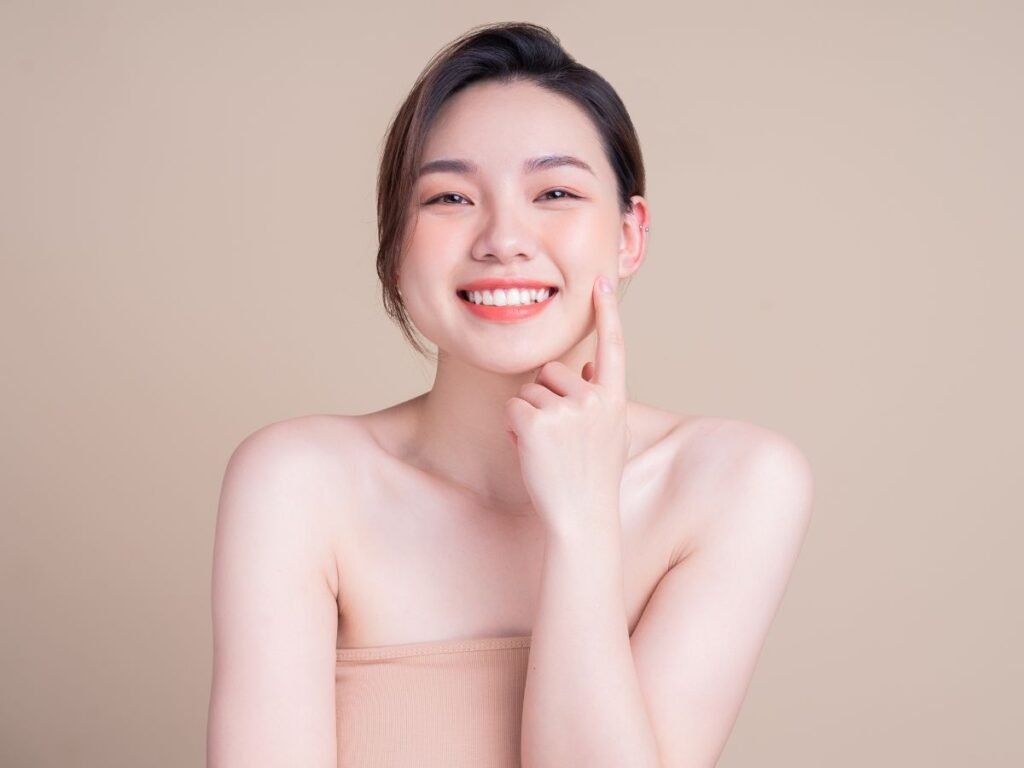 Smiling woman with glowing skin, using the 10 best beauty products for women