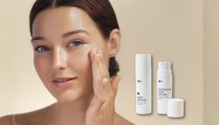 Woman applying face cream to her cheek beside Alloy face cream and Alloy tretinoin face cream bottles